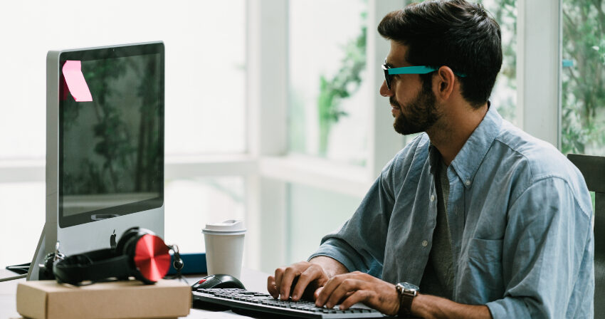 Mann am Computer der sein Werbe-Display-Layout gestaltet